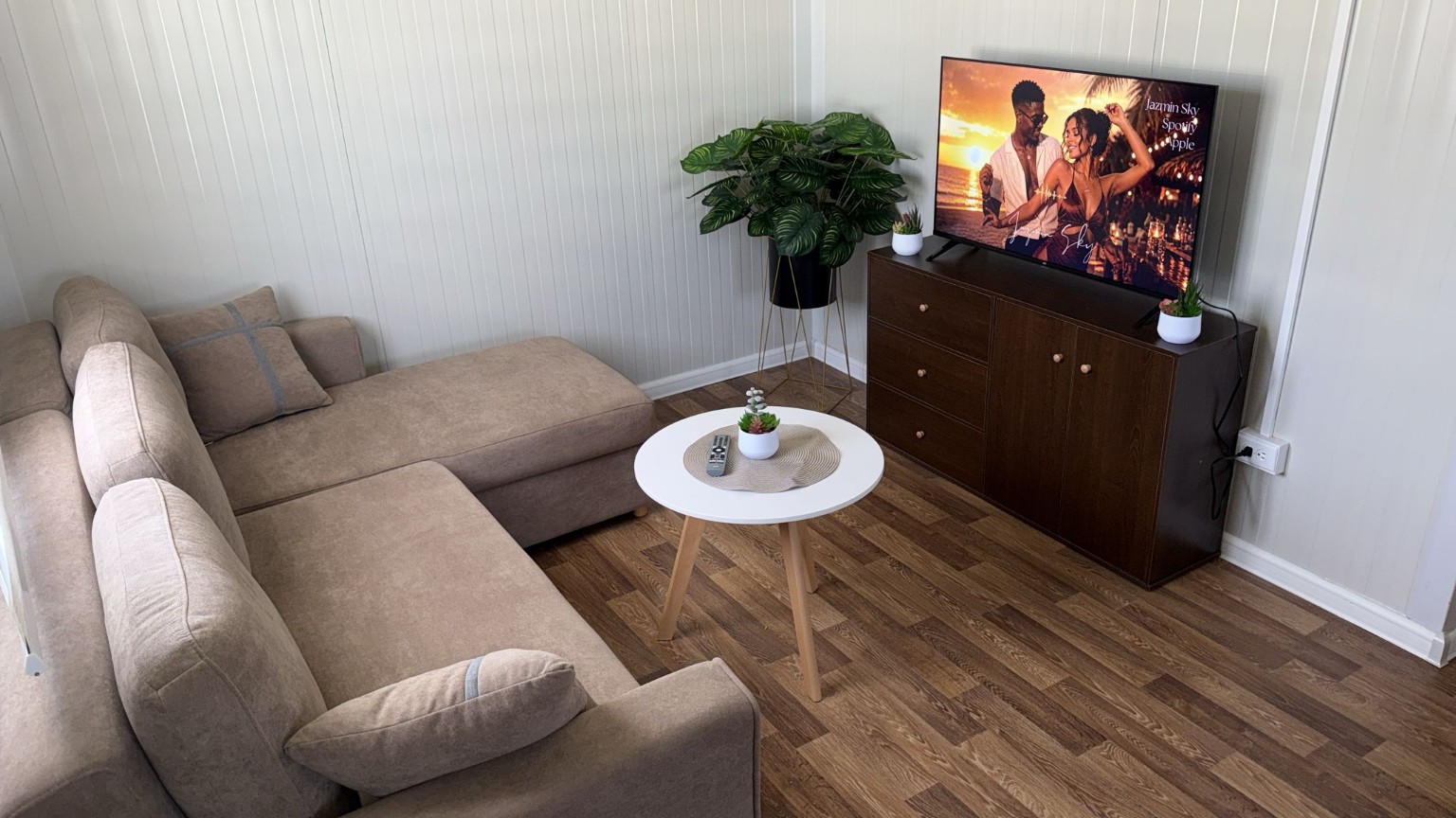 Lichte woonkamer met hoekbank en televisie
